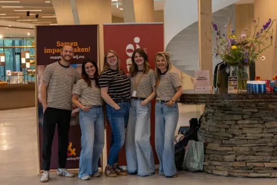 vrouwen en 1 man poseren voor een groepsfoto