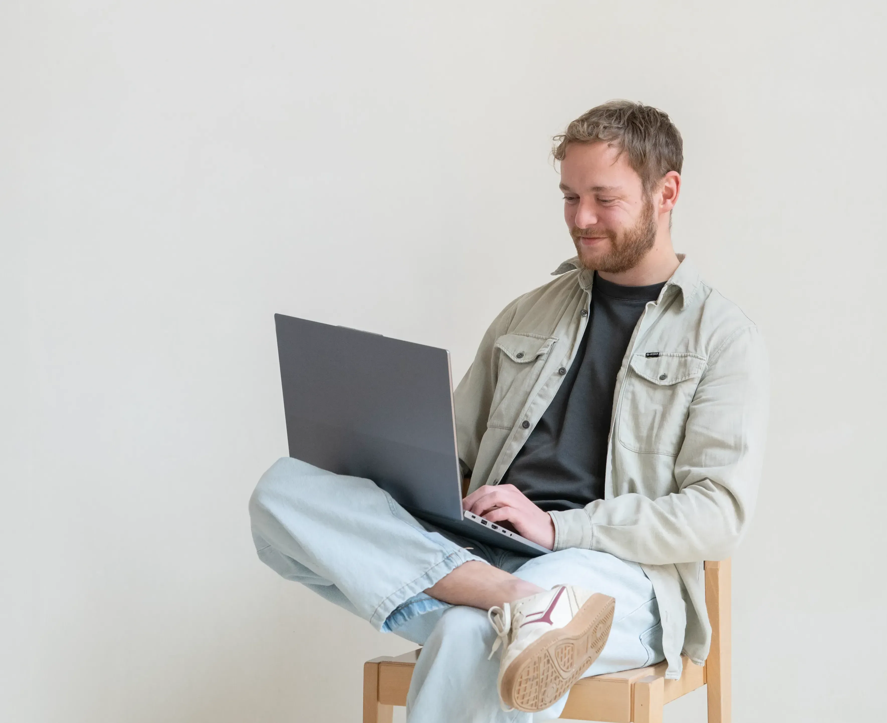 Man in stoel kijkend naar laptop