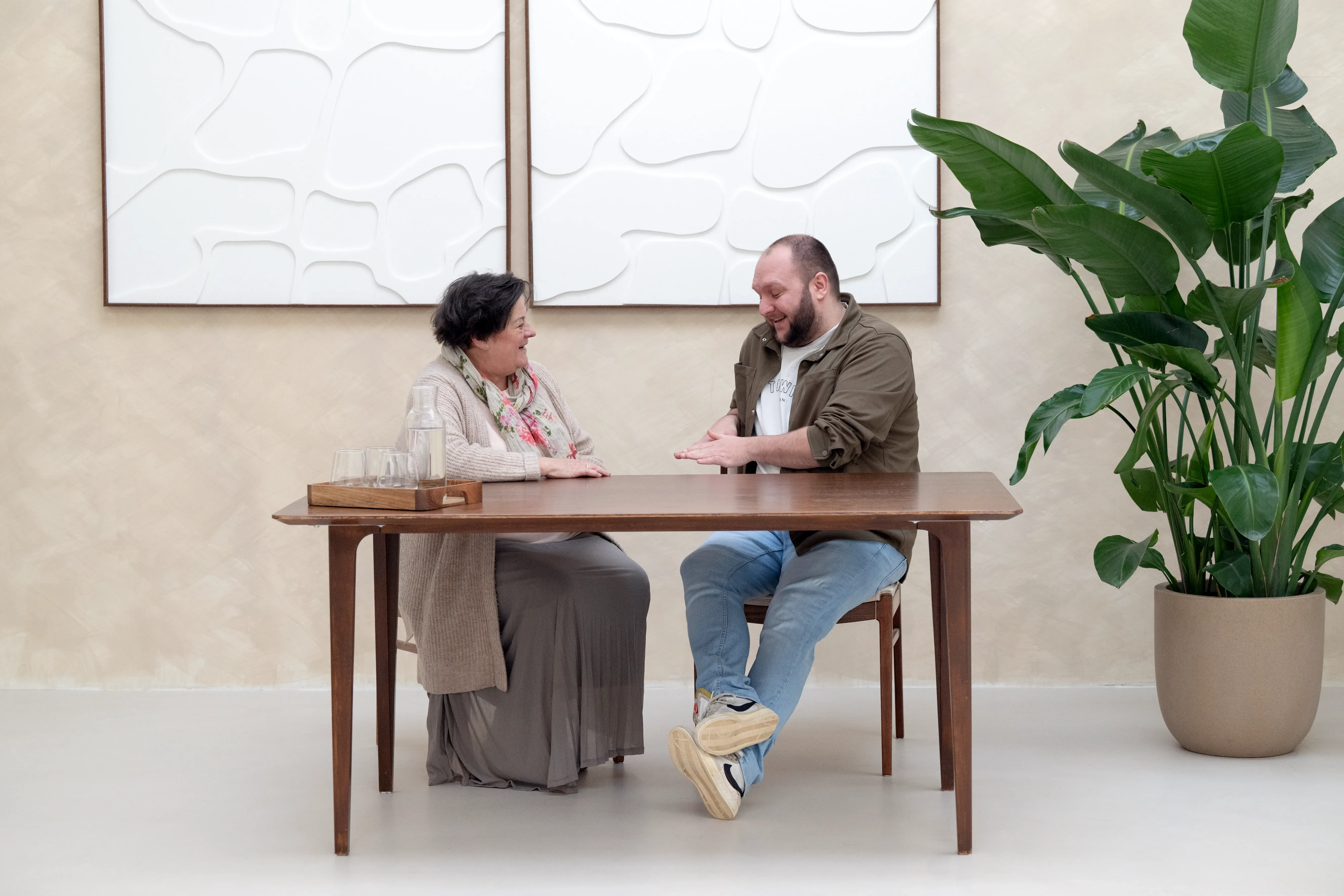 Man en vrouw zitten aan tafel naar elkaar te lachen