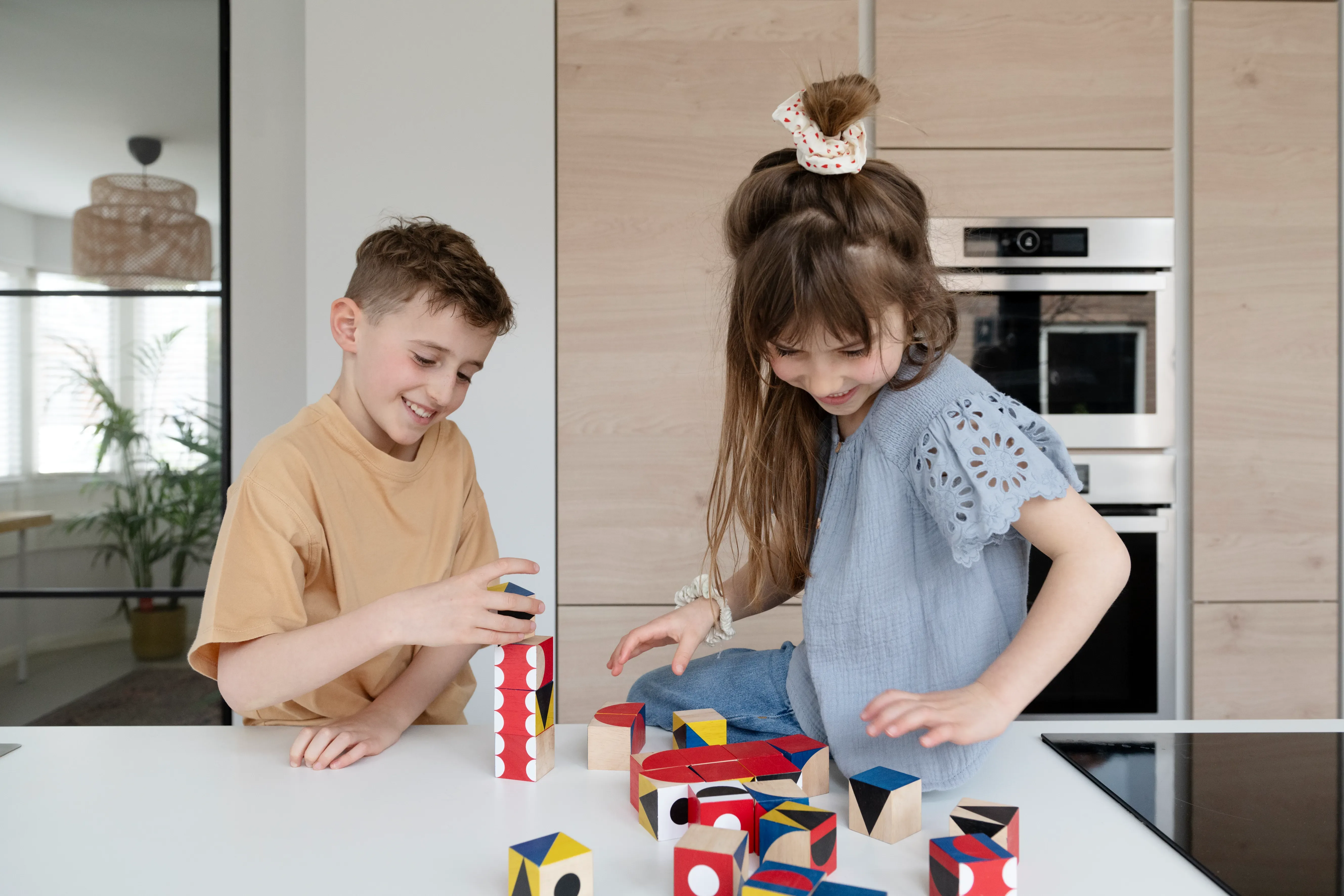 Twee kinderen spelend met blokken in de keuken