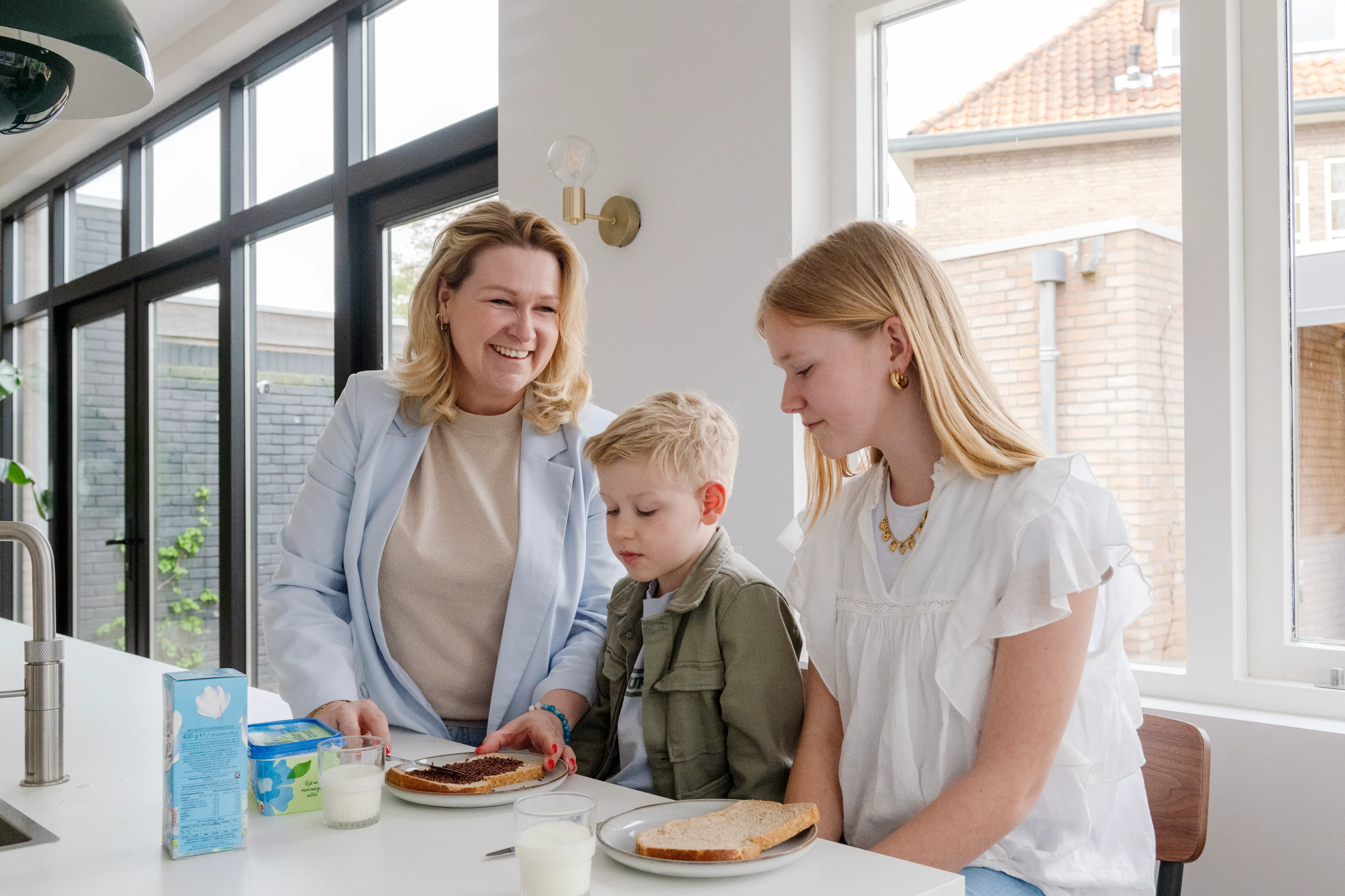 Moeder met dochter en zoon aan keukentafel