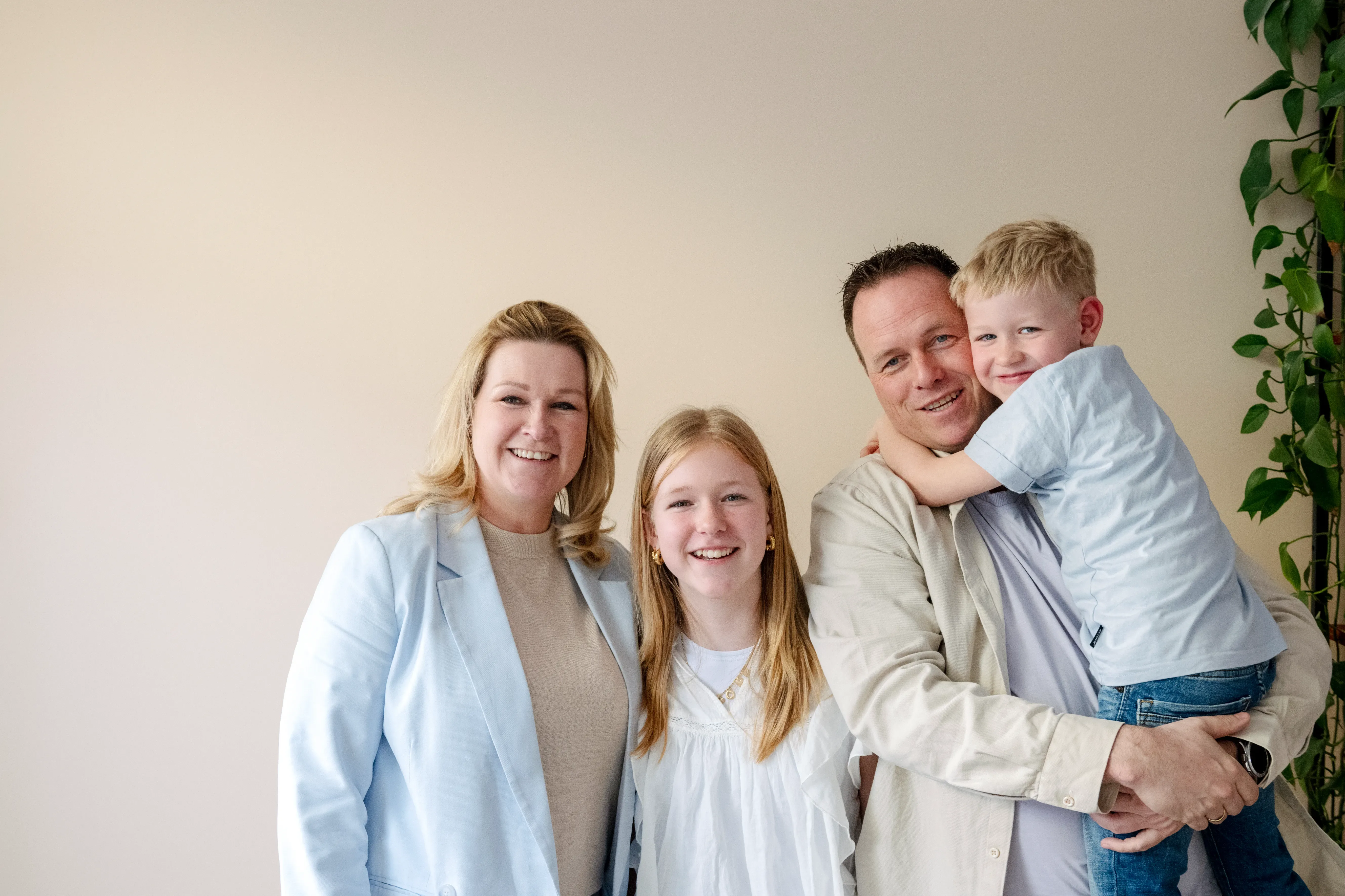 Gezin van man, vrouw, dochter en zoon lachend naar de camera