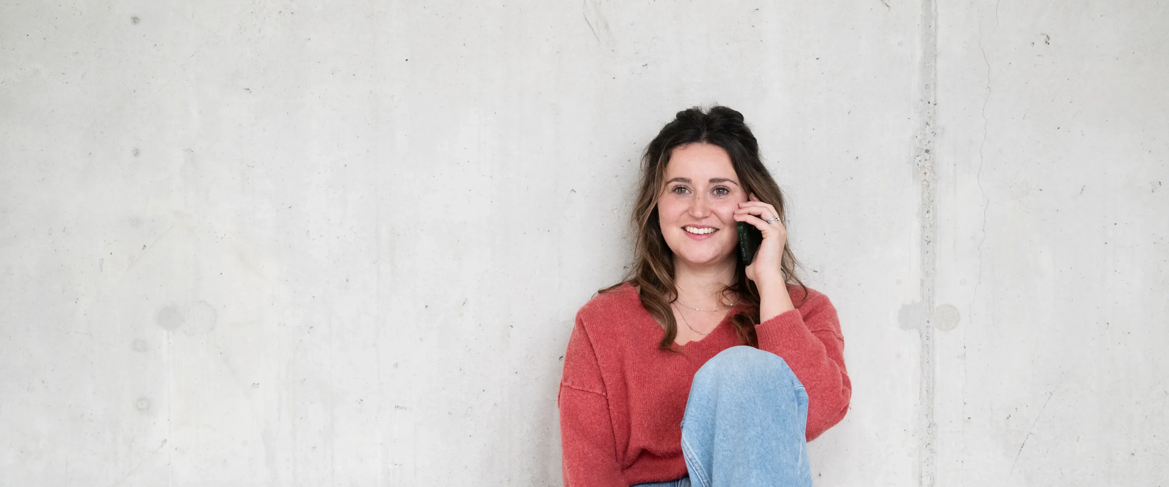 Vrouw zit op de grond en is aan het bellen