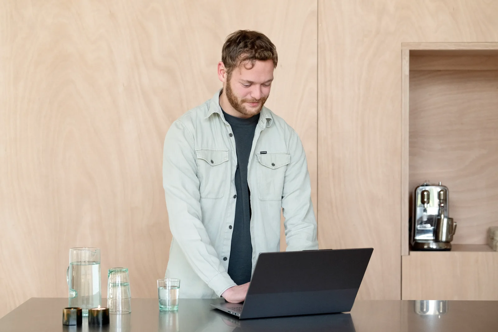 Man staat achter laptop